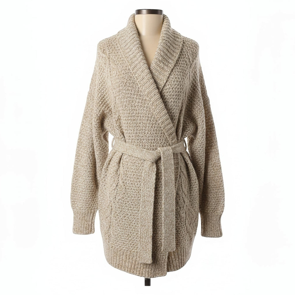 Oversized beige chunky knit wrap cardigan with shawl collar and matching belt tie. Cable knit details on sleeves and front panels.