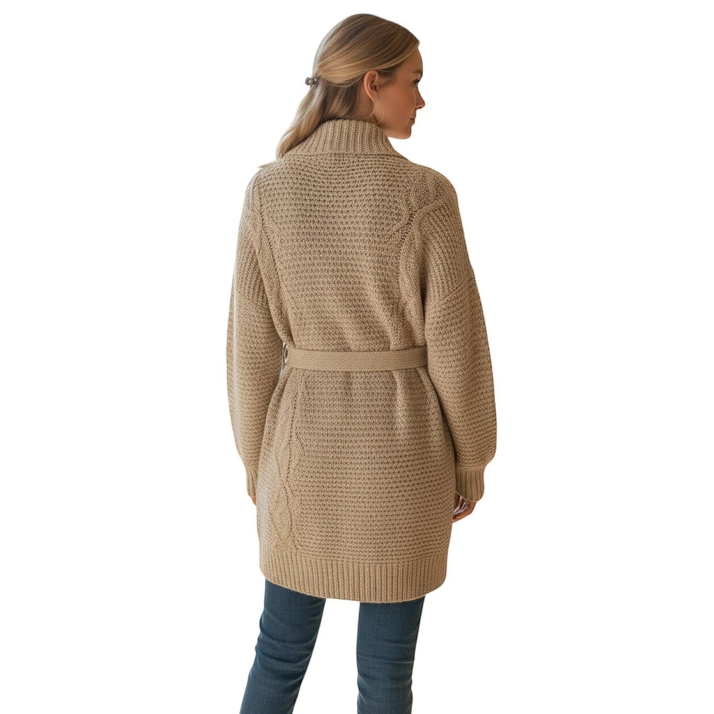 Woman wearing a beige chunky knit oversized wrap cardigan with a belt tie, featuring cable knit detailing on the back.