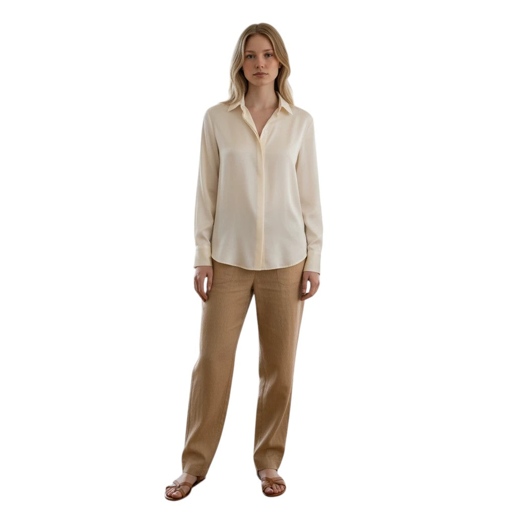 Cream silk-feel button-front blouse with a classic collar and long sleeves, worn by a woman with tan trousers.