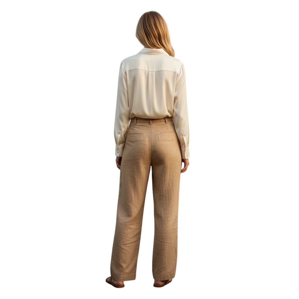 Woman wearing a cream silk button-front blouse and tan wide-leg trousers, viewed from the back.