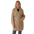 Woman wearing a beige cable knit belted cardigan sweater with a shawl collar and long sleeves.